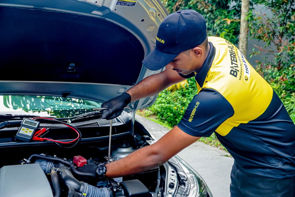 Baterihub technician replacing a car battery with professional tools