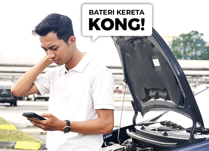 A worried man stranded with a dead car battery, checking his phone for Baterihub roadside assistance.