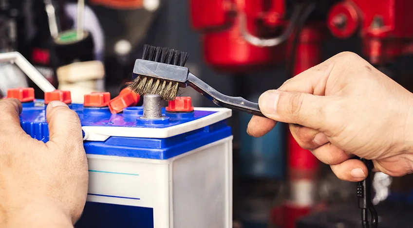 Mechanic,Cleaning,A,Battery,Connections,,brush,And,Insert,The,Brush