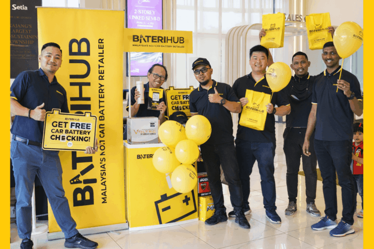 Setia Amam Sari Blog Cover BateriHub team promoting free car battery checking at a mall booth with yellow branding, balloons, and promotional bags.