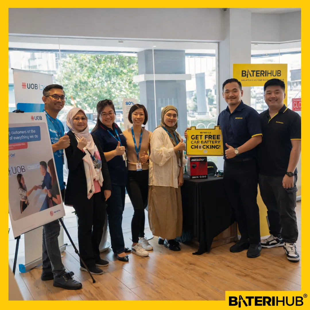 BateriHub and UOB team members posing during a retail activation event featuring free car battery checking promotion at a Malaysia outlet.