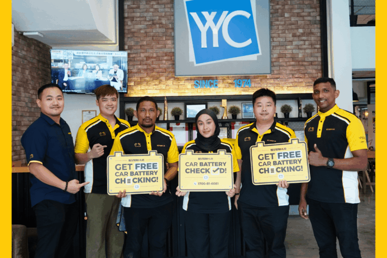 YYC Battery Checking BateriHub team posing at YYC office holding “Free Car Battery Checking” signs during corporate battery health check event.