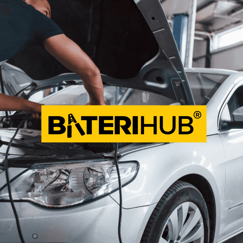 A professional technician performing a Honda City battery replacement and checking engine terminals in a workshop.