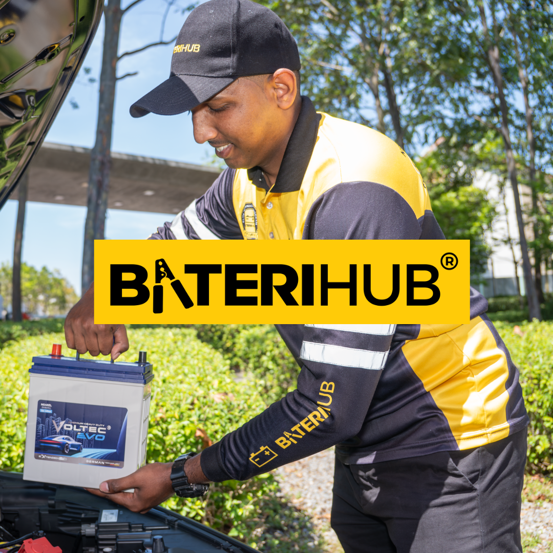 BateriHub technician installing a Voltec EVO car battery into a vehicle during an on-site battery replacement service in Malaysia.